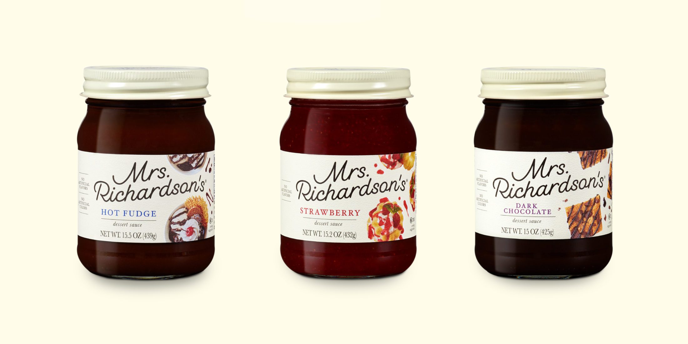 3 glass jars of Mrs. Richardson's Dessert Sauces with cream metal lids. From left to right, Hot Fudge, Strawberry, and Dark Chocolate.